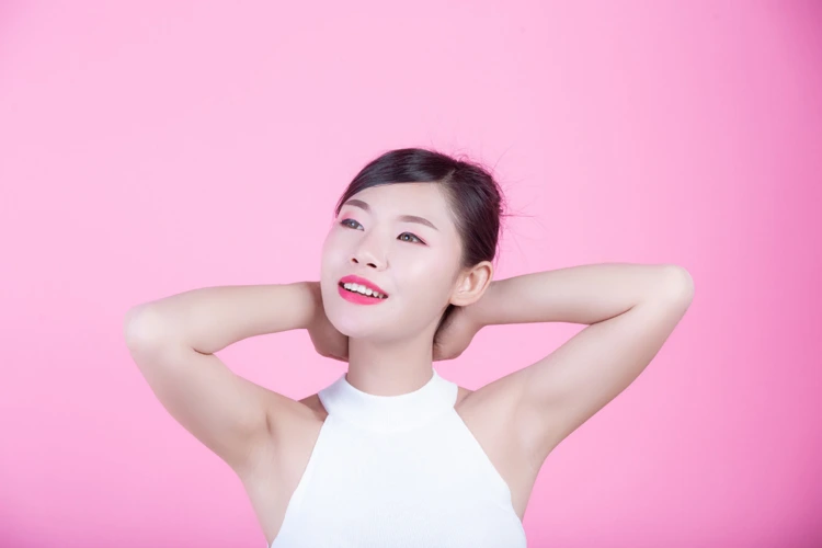 Lady showing off both clean and shaved underarms from IPL hair removal treatment.